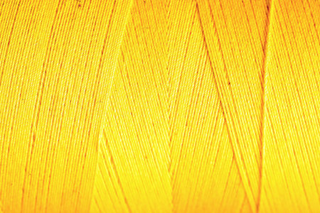 yellow thread fabric wool yarn wrapped in a spool of threads and textiles great for a background