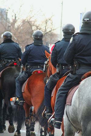 riot or protest soldiers of a police state policemen on horse backの写真素材