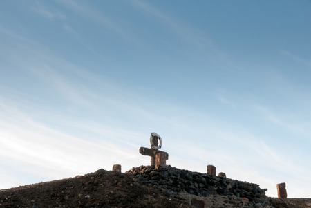 A shot of a cross and a lifebuoy on a old construction in the coastの写真素材