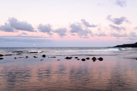 A shot of the yellow moon rising at sunsetの写真素材