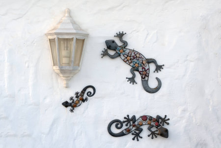 A shot composition a three decorative artificial lizards and old lamp in a wallの写真素材