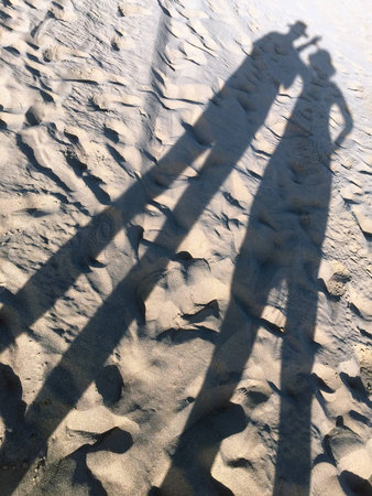 A shot of the silhouettes of a couple on the sandの写真素材