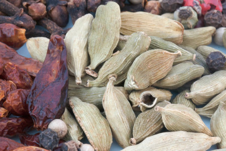 A macro species beans composition of different colors and textures (cardamom, pepper, cloves, chillies and cinnamon)の写真素材
