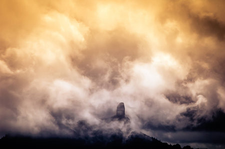 A view of the Nublo Rock surrounded by clouds at sunset in the highlands of Grand Canary island