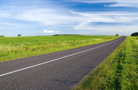 Summer landscape with rural road and cloudy skyの写真素材
