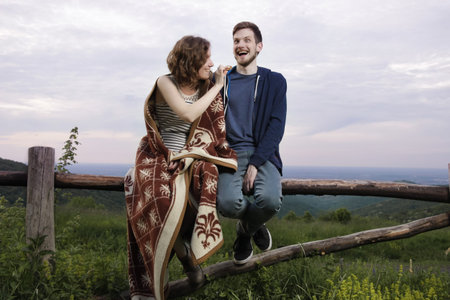 Silly expression boy, girl feeding him a cookie.の写真素材