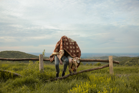 Funny girl boy wrapped blanket outdoors.の写真素材