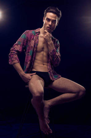 one young handsome man 20s model sexy body fit slim, fashionable shirt, blue yellow colorsの写真素材