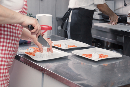 closeup two people uniforms cooking plates, coomercial kitchenの写真素材