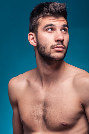face head shoulders, man looking above up, blue background studioの写真素材