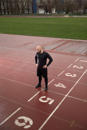 one man looking down, sport venue, sad depressed.