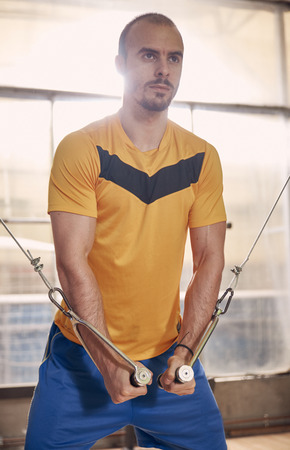 one young man, wearing sport clothes, exercise on resistance bands, in old beaten up gym interior.western shot.の写真素材