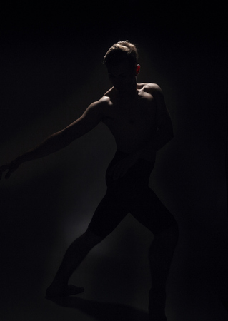 one ballet dancer, dark black background, backlit backlighting.の写真素材