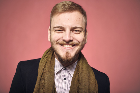 one young man, 20-29 years old, looking to camera, candid smiling happy. headshot, close-up of head/face, real person, not model. looking friendly. pink background, studio shot, photo shoot.の写真素材
