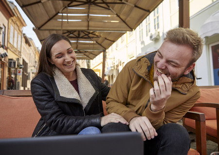 two people, 20 - 29 years old, candid laughing out loud. sitting in a cafe.の写真素材