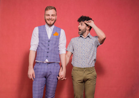one young silly feminine man looking at his partner, in awe and shock. posing in studio,...