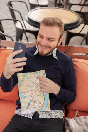 one young man, traveler or tourist, making a selfie on his smart-phone. Cute and candidly smiling,...
