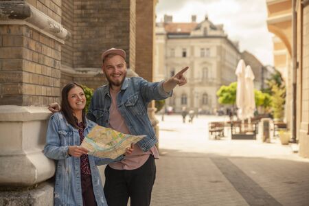 two friends, or couple, looking at a city map while one man is pointing finger. Location Novi Sad, Serbia.の写真素材