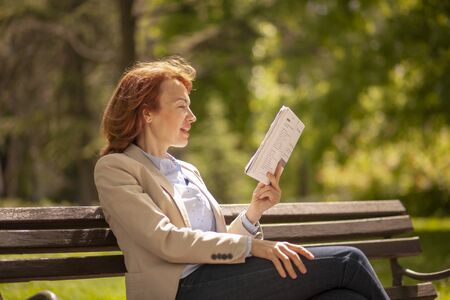 one mature woman, reading aloud while learning from book.の写真素材