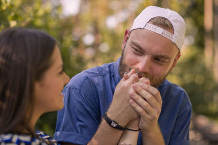 Guy kisses girl's hand. Looking at each other.の写真素材