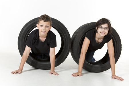 A boy and a girl are coming through tiresの写真素材