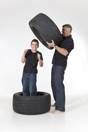 Father and son are building tire fortress isolated on whiteの写真素材