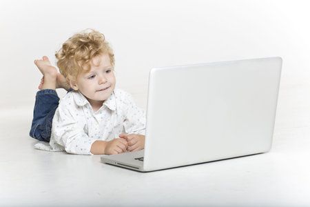 Smiling toddler on the floor with computer