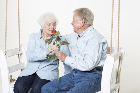 Senior man presents his wife with a flowerの写真素材