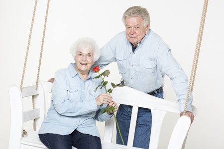 Senior man presents his wife with a flowerの写真素材