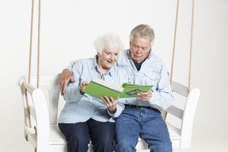 Senior couple looks at picture albumの写真素材