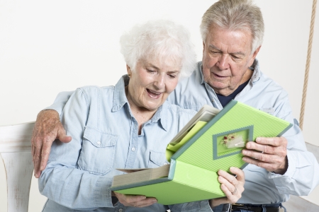 Senior couple looks at picture albumの写真素材