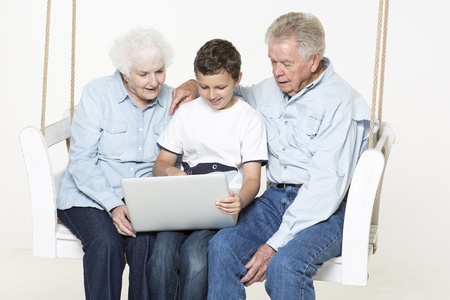 Grandson helps his grandparent with computer questionの写真素材