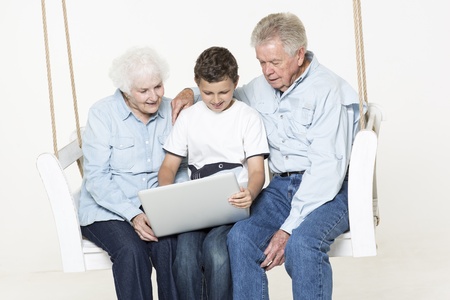 Grandson helps his grandparent with computer questionの写真素材