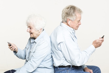 Senior couple is listening to music in earphonesの写真素材