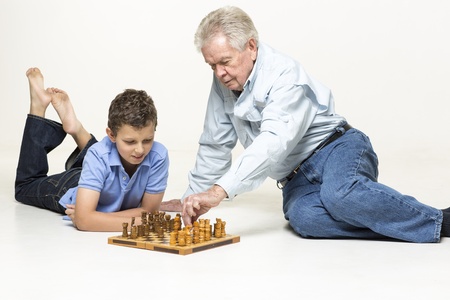 Grandfather playing chess with his grandson の写真素材