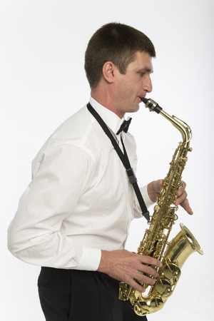 Young man plays saxophoneの写真素材