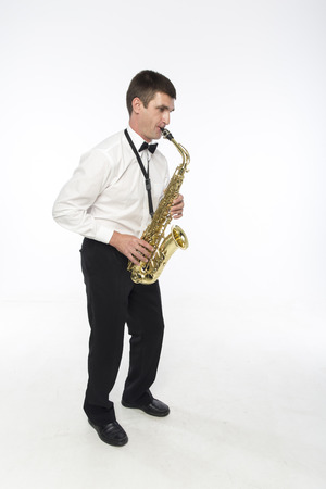 Young handsome man plays saxophoneの写真素材