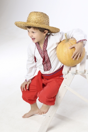 Young farmer boy with a pumkinの写真素材