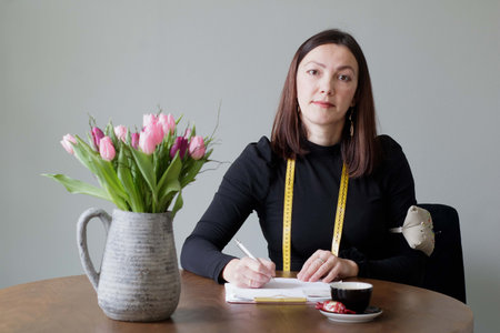 Woman tailoring designer draws a new project for atelier clients . Individual entrepreneur atelier...