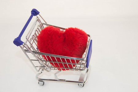 Valentines day concept. Miniature shopping carts on the store that is fluffy and soft heart on a white background.の写真素材