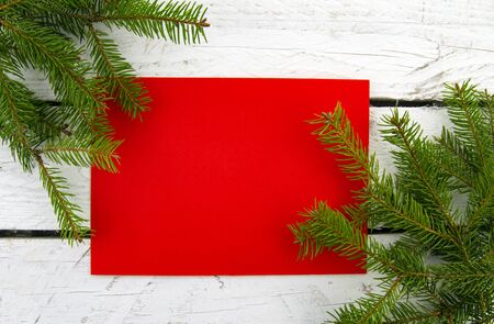 It's Christmas time! Festive red blank card with Christmas tree on white wooden background.の写真素材
