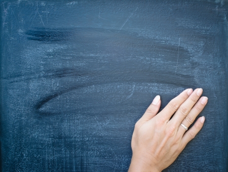 Erasing the chalkboard by handの写真素材