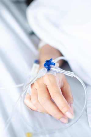 close up of saline solution with patients handの写真素材
