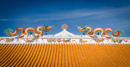 twin dragons statue on roof with blue sky backgroundの写真素材