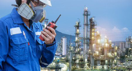 technician with gas mask against petrochemical plant background  communicate by walkie-talkie