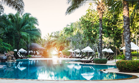 swimming pool in tropical resort.swimming pool with palm tree and bed for relax.