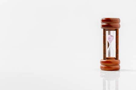 Modern hourglass on white background with copy space. Hourglass time passing concept for business deadline, urgency, and running out of time.の写真素材