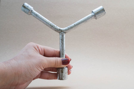 Holding a 3 way lug wrench with human left hand