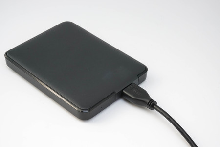 black external hard disk in white backgroundの写真素材