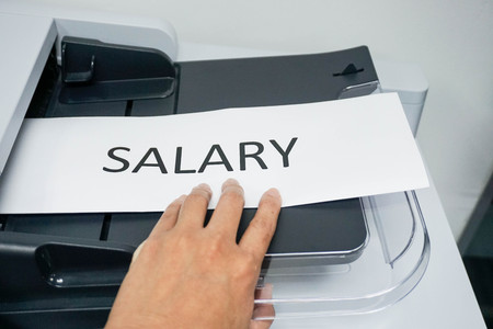 Hold a paper of salary on the printer for copyの写真素材